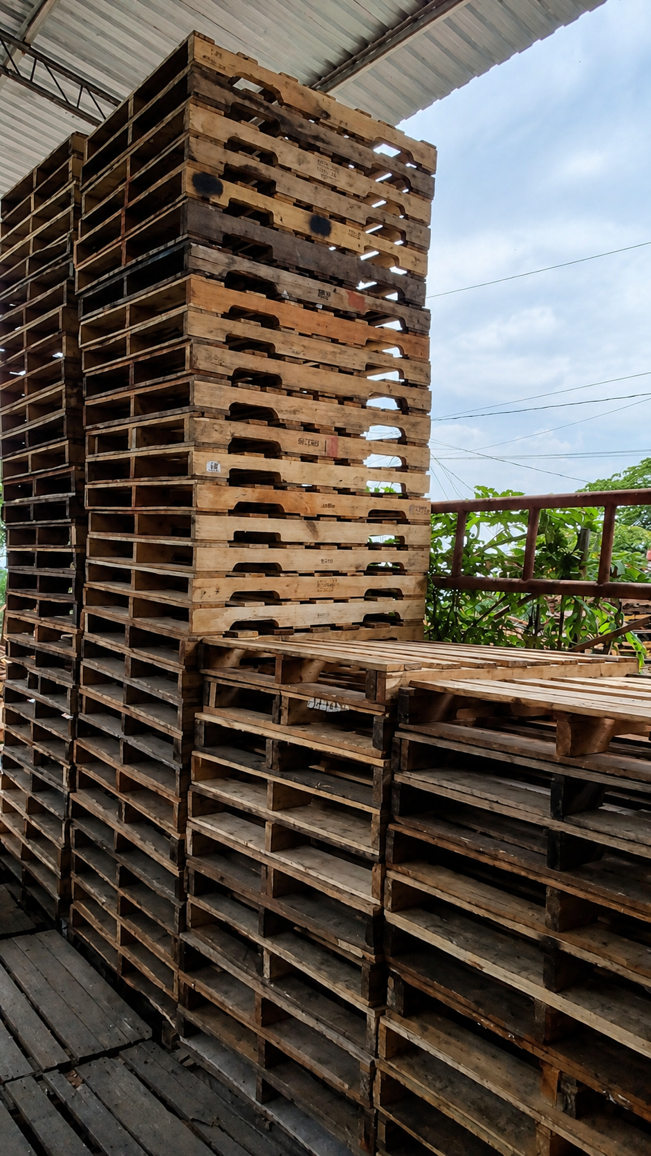 Tarimas de madera recicladas de alta calidad apiladas en el patio de Inversiones Galeano
